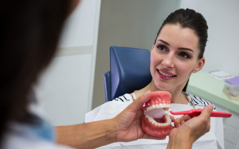 dentist-showing-set-model-teeth-patient